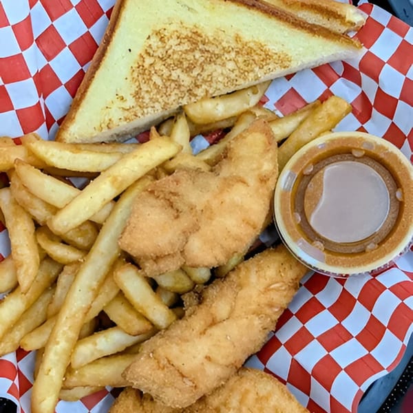 Zee's Kitchen American meal with crispy chicken tenders, golden fries, grilled cheese, and dipping sauce.